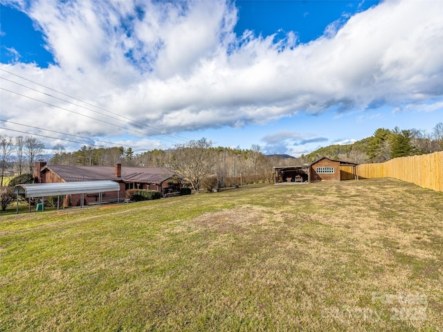 view of yard featuring an outdoor structure and a carport