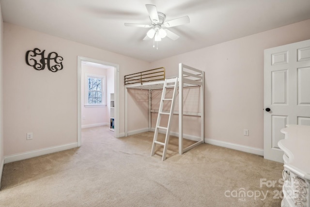 unfurnished bedroom with ceiling fan and light colored carpet