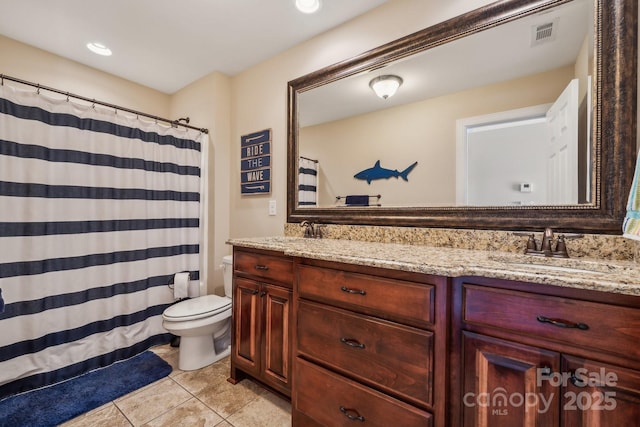 bathroom featuring toilet, vanity, and tile patterned flooring