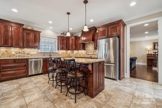 kitchen featuring stainless steel appliances, custom exhaust hood, light stone counters, and hanging light fixtures