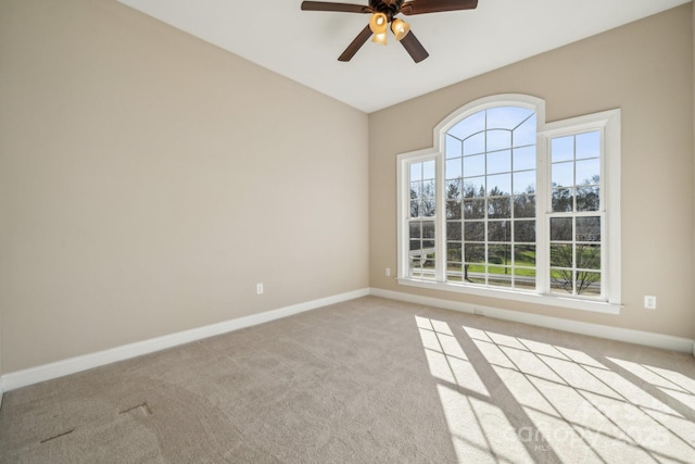 unfurnished room with light colored carpet, baseboards, and ceiling fan