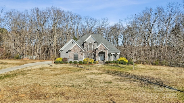 view of front of house featuring stone siding and a front yard