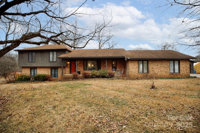 tri-level home featuring a front yard and covered porch