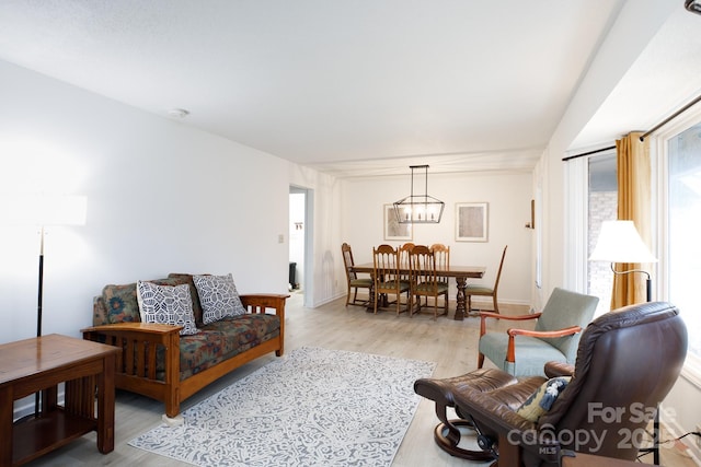 living room featuring light wood-type flooring and an inviting chandelier