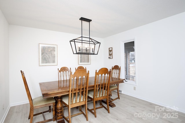 dining area featuring light hardwood / wood-style floors and a notable chandelier