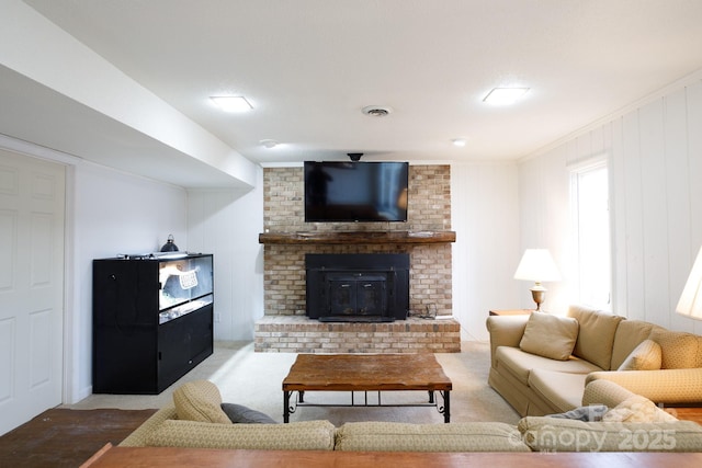 living room with a brick fireplace, carpet flooring, ornamental molding, and wooden walls