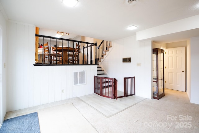 stairway featuring wooden walls and carpet flooring