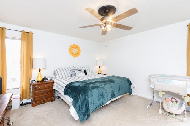 bedroom with ceiling fan and light colored carpet