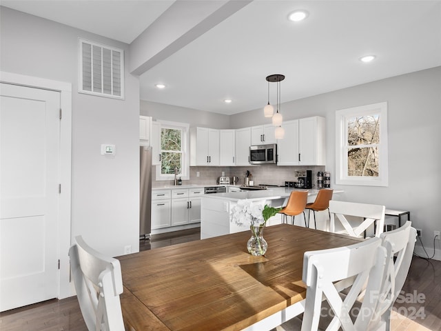 dining space with dark hardwood / wood-style floors and sink