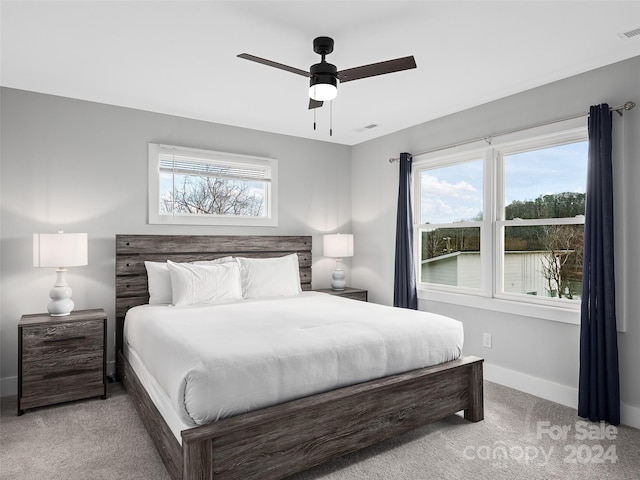 carpeted bedroom with multiple windows and ceiling fan