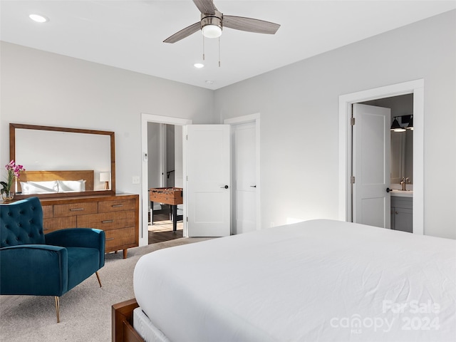 carpeted bedroom featuring connected bathroom, ceiling fan, and sink