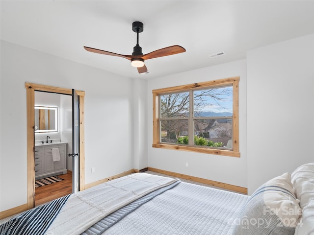 bedroom with connected bathroom, ceiling fan, hardwood / wood-style floors, and sink