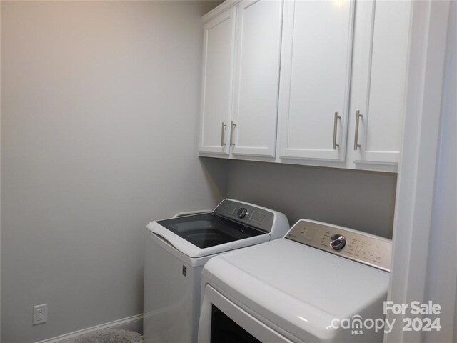 laundry room with washer and dryer and cabinets