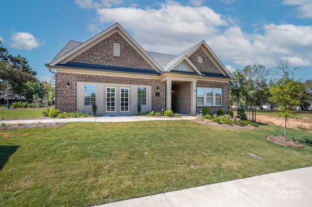 craftsman house featuring a front yard and brick siding