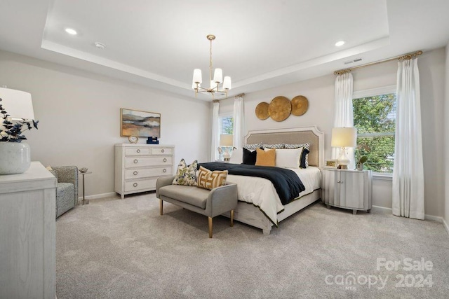 carpeted bedroom with a tray ceiling and a notable chandelier