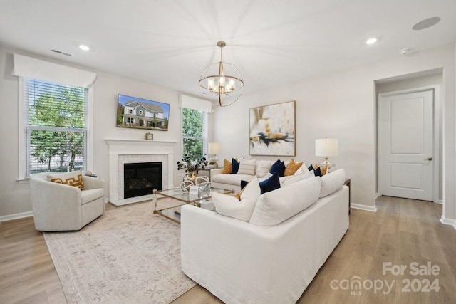 living room featuring a chandelier and light wood-type flooring