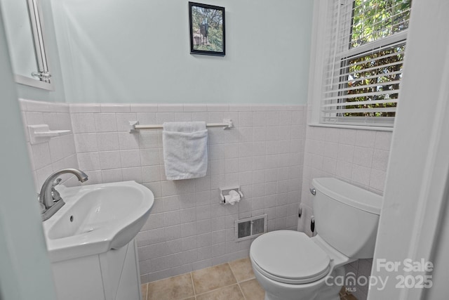 bathroom with tile patterned flooring, vanity, tile walls, and toilet