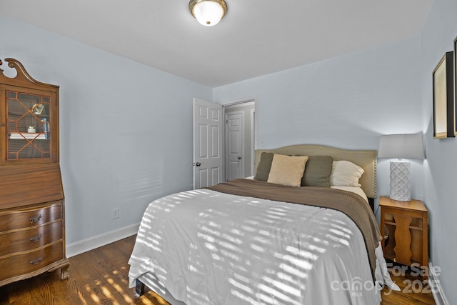 bedroom with dark hardwood / wood-style flooring