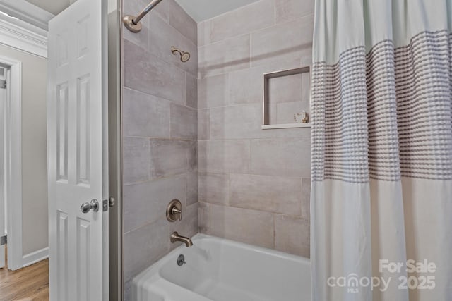 bathroom featuring wood-type flooring and shower / bathtub combination with curtain