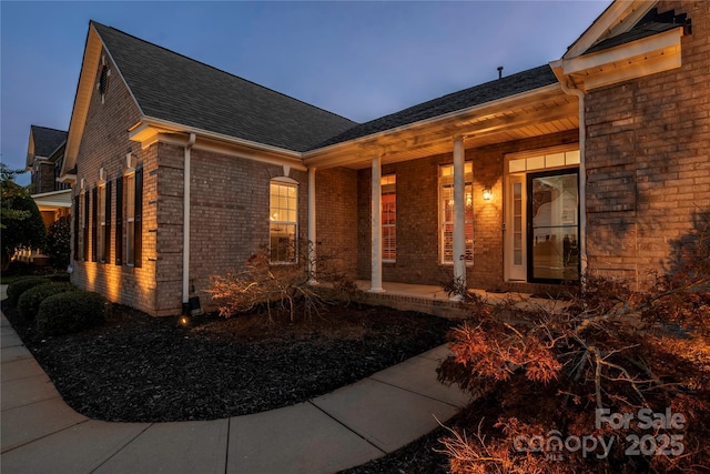 exterior entry at dusk featuring a porch