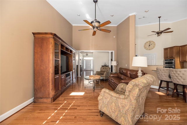 living room with crown molding, hardwood / wood-style floors, and ceiling fan