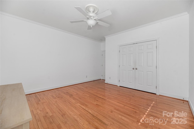 unfurnished bedroom featuring ceiling fan, light wood-type flooring, crown molding, and a closet