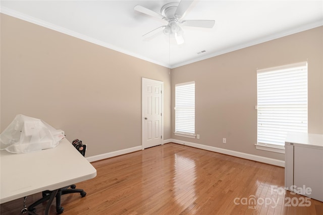 home office featuring wood-type flooring, crown molding, ceiling fan, and a healthy amount of sunlight