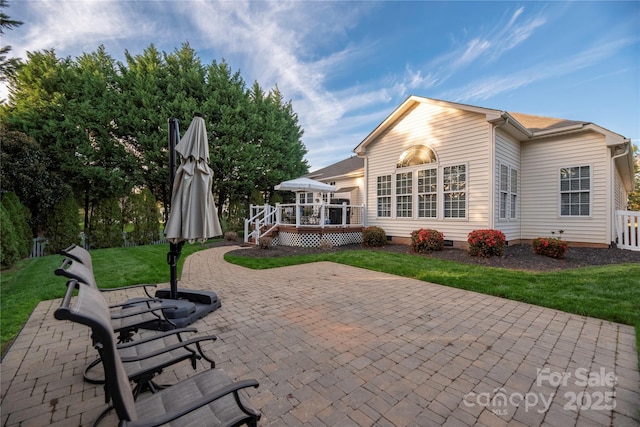 back of property with a patio area, a deck, and a yard