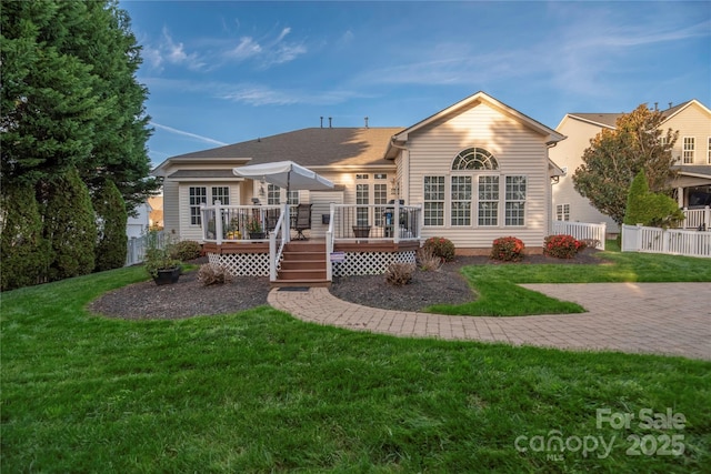 back of property featuring a wooden deck and a yard