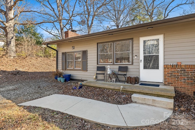 view of exterior entry with a patio