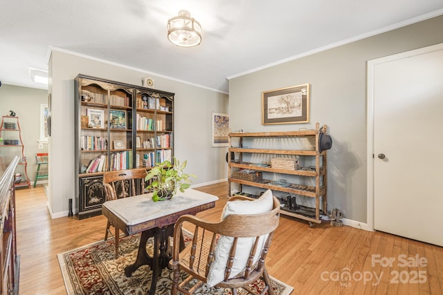 sitting room with ornamental molding and light hardwood / wood-style flooring