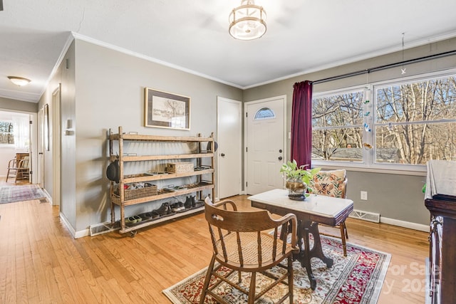 dining room featuring ornamental molding, light hardwood / wood-style floors, and a healthy amount of sunlight