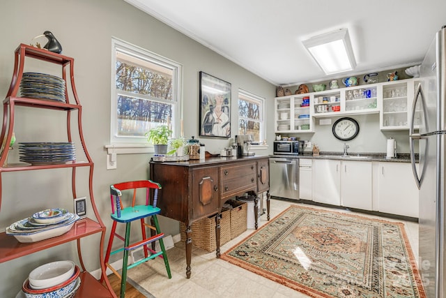 kitchen with sink, white cabinets, dark stone counters, and appliances with stainless steel finishes