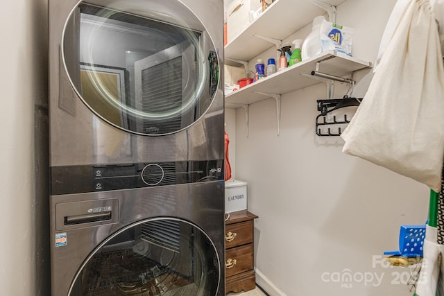 washroom featuring stacked washer and clothes dryer