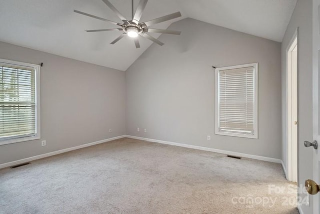 carpeted spare room with ceiling fan and lofted ceiling