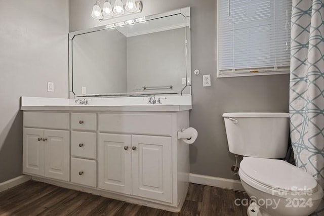 bathroom with hardwood / wood-style flooring, vanity, and toilet