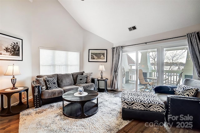 living room with hardwood / wood-style floors and high vaulted ceiling