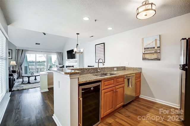 kitchen with stainless steel appliances, sink, beverage cooler, and kitchen peninsula