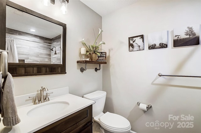 bathroom featuring a shower with curtain, vanity, toilet, and a textured ceiling