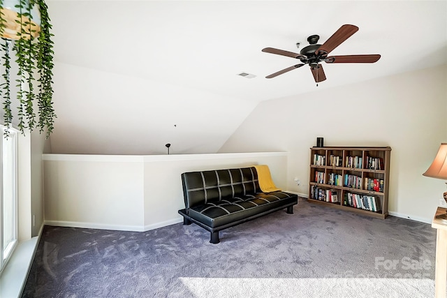 sitting room with dark colored carpet and vaulted ceiling