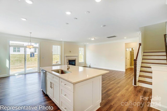 kitchen featuring sink, a center island with sink, dishwasher, white cabinetry, and hanging light fixtures