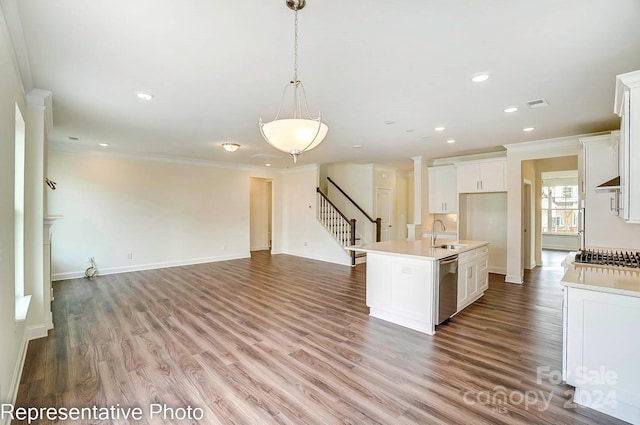 kitchen with white cabinetry, sink, a kitchen island with sink, appliances with stainless steel finishes, and ornamental molding