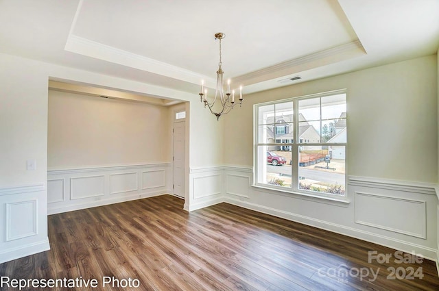 unfurnished dining area with dark hardwood / wood-style flooring, a tray ceiling, and an inviting chandelier