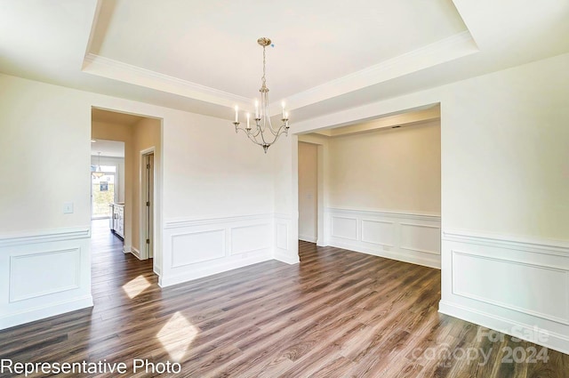 unfurnished room featuring a tray ceiling, dark hardwood / wood-style flooring, and a notable chandelier