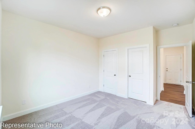 unfurnished bedroom featuring light carpet