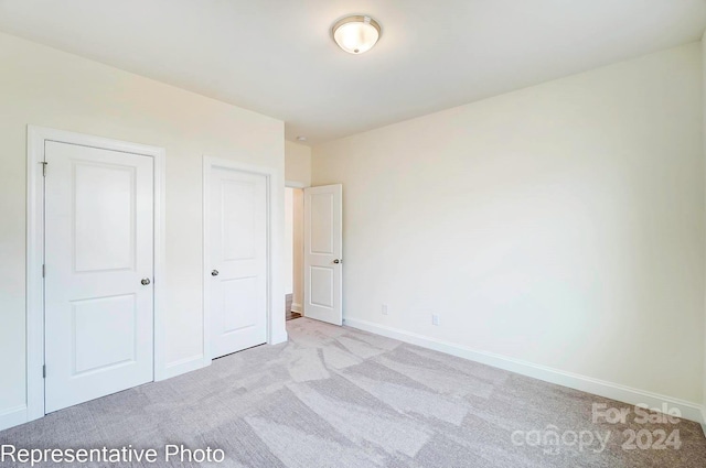 unfurnished bedroom with light colored carpet