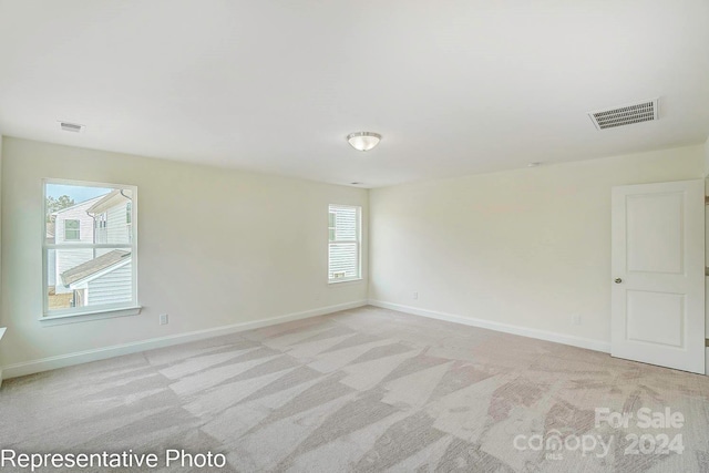 empty room with a healthy amount of sunlight and light carpet