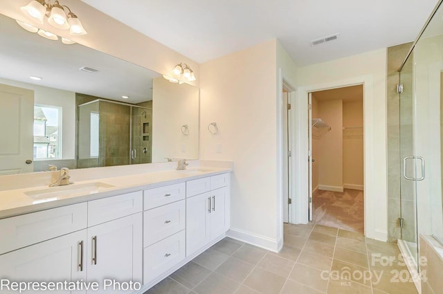 bathroom with vanity, tile patterned floors, and a shower with door