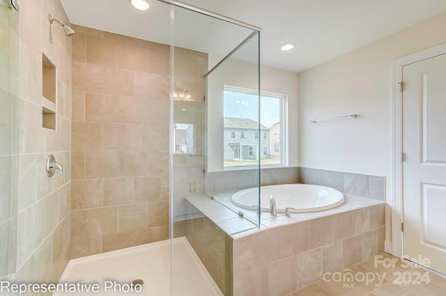 bathroom featuring tile patterned flooring and separate shower and tub