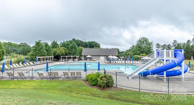 pool with a patio, fence, playground community, and a yard